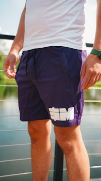 a man wearing purple shorts with white lettering